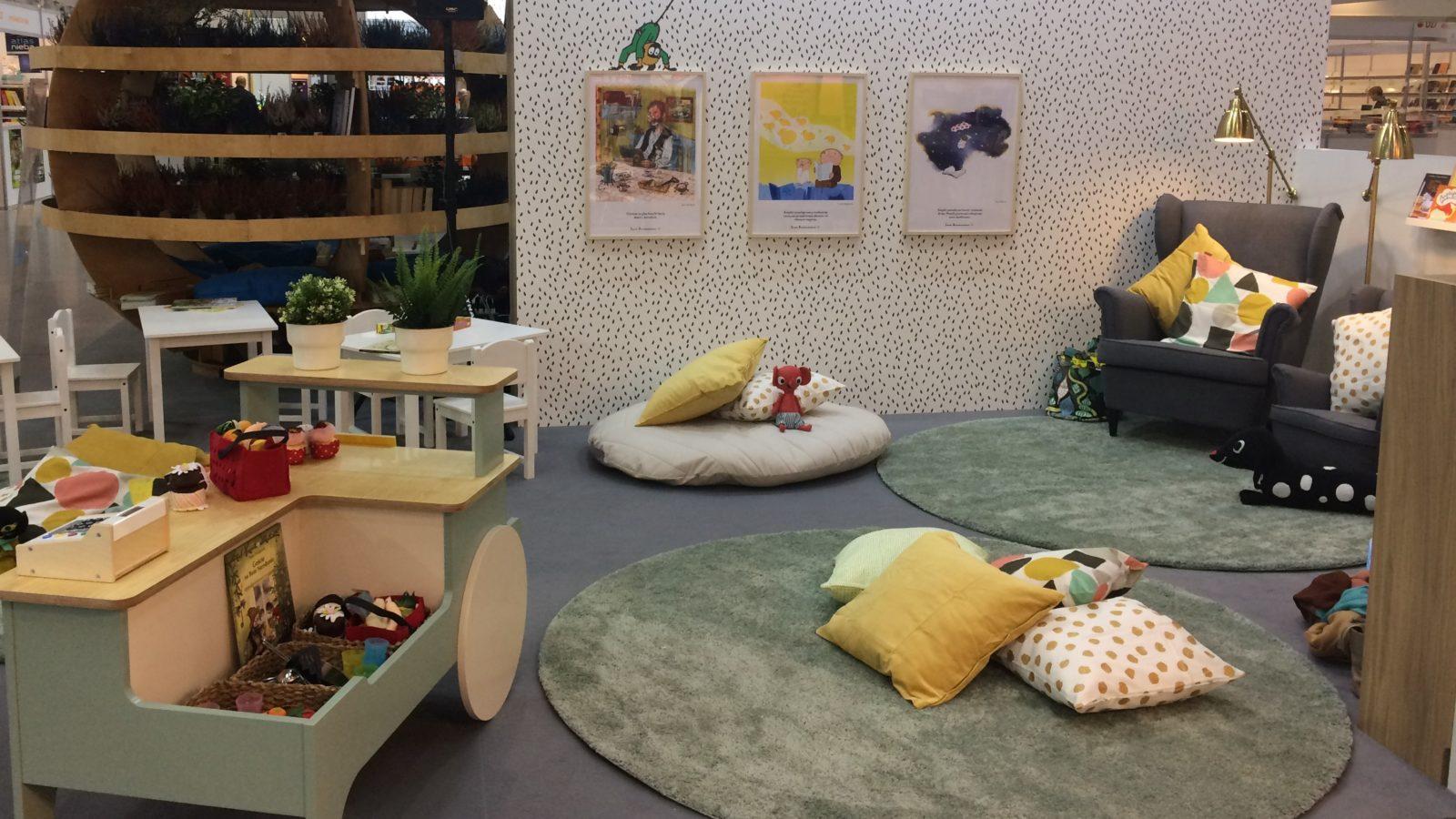 An area for children with toys, carpets, pillows and posters.