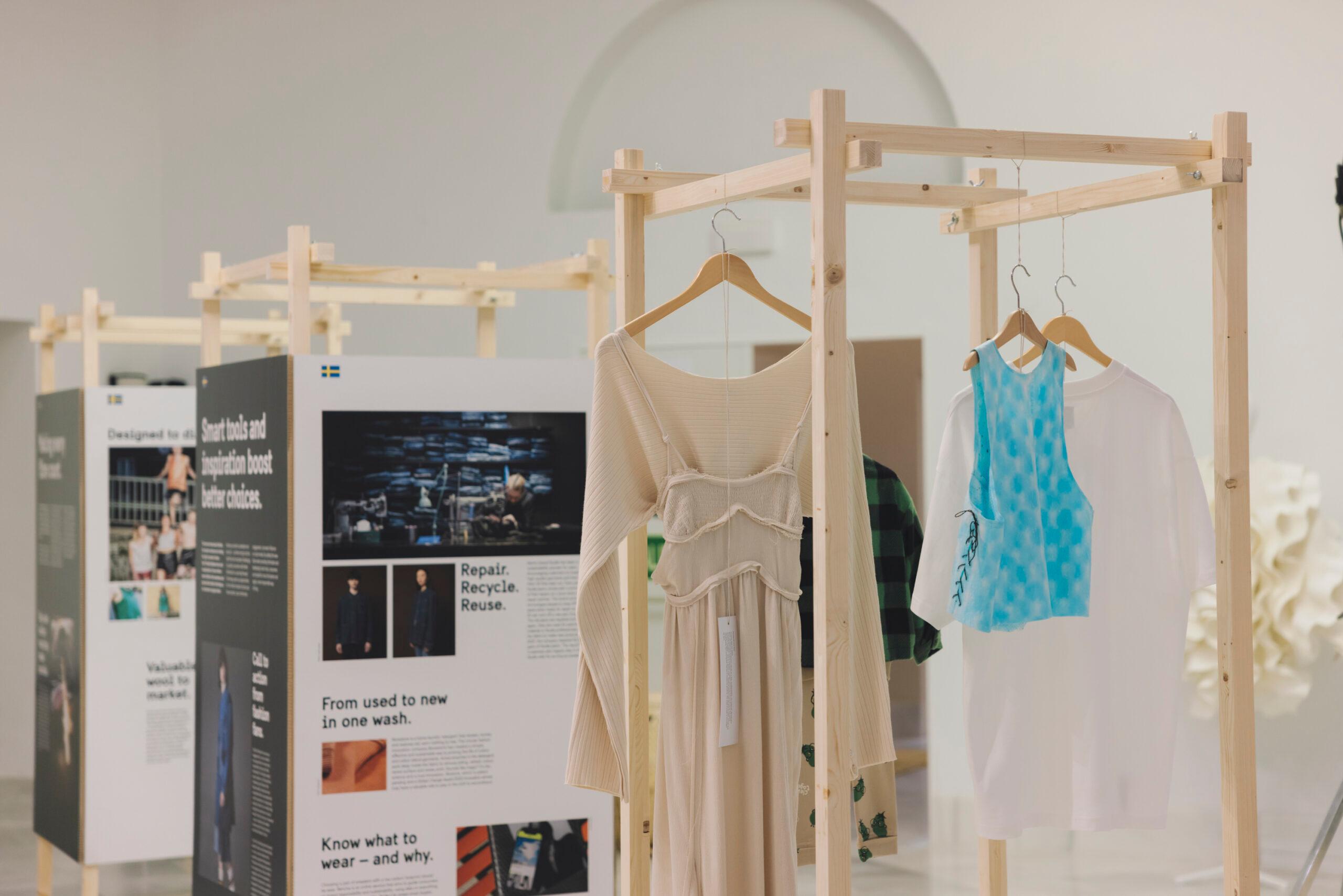 Garments hanging on a wooden exhibition module.