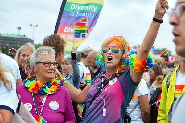 People cheering in a Pride parade.