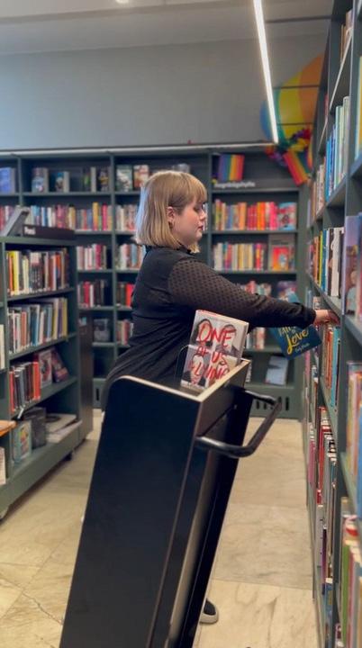 A librarian stacking books in the Tranströmer library.