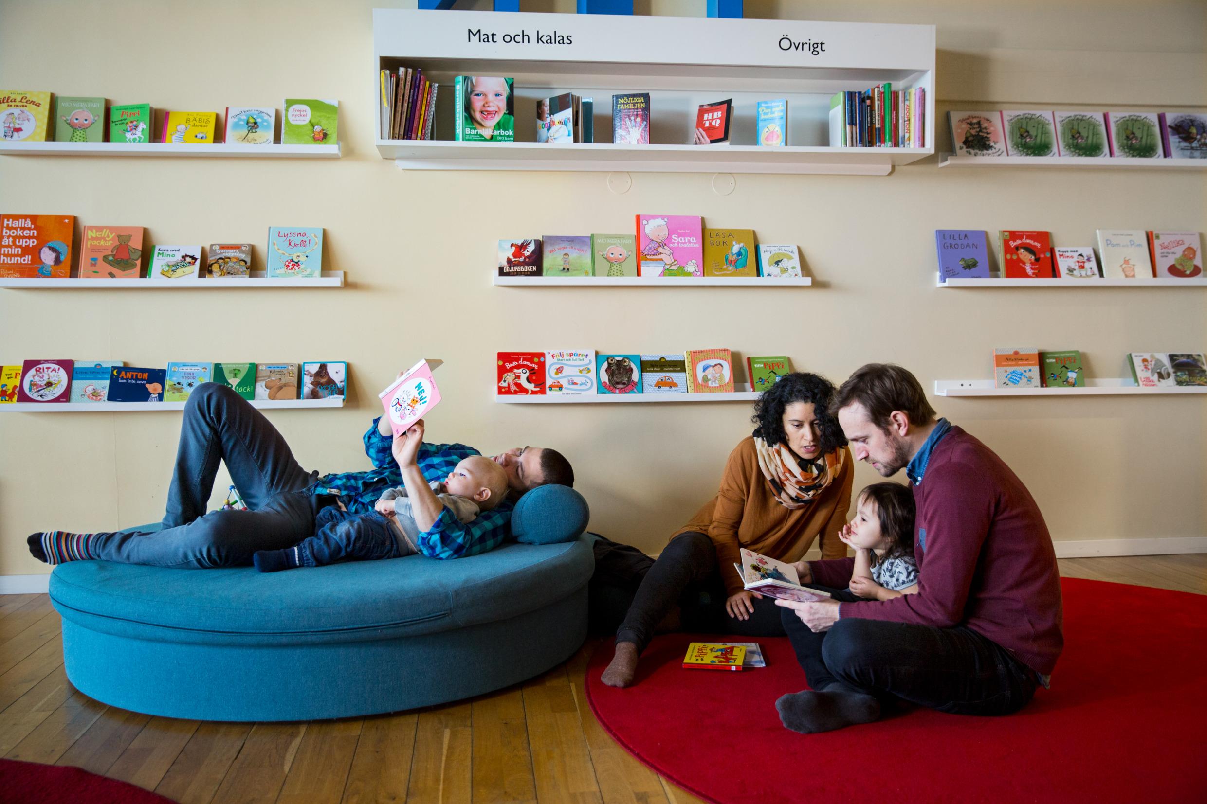 Families reading children's books at a Swedish library.