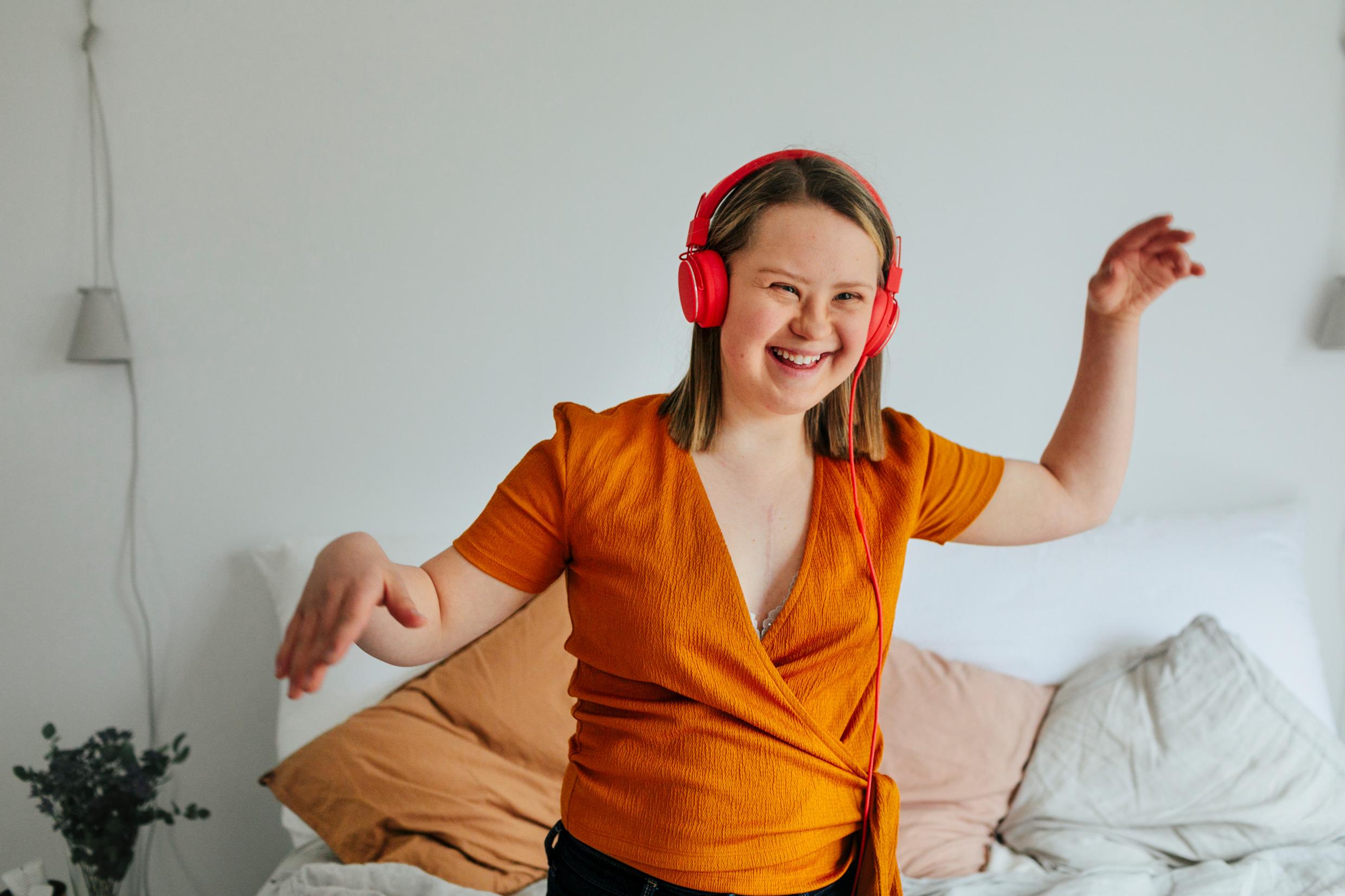 A young girl with Downs syndrome listening to music.