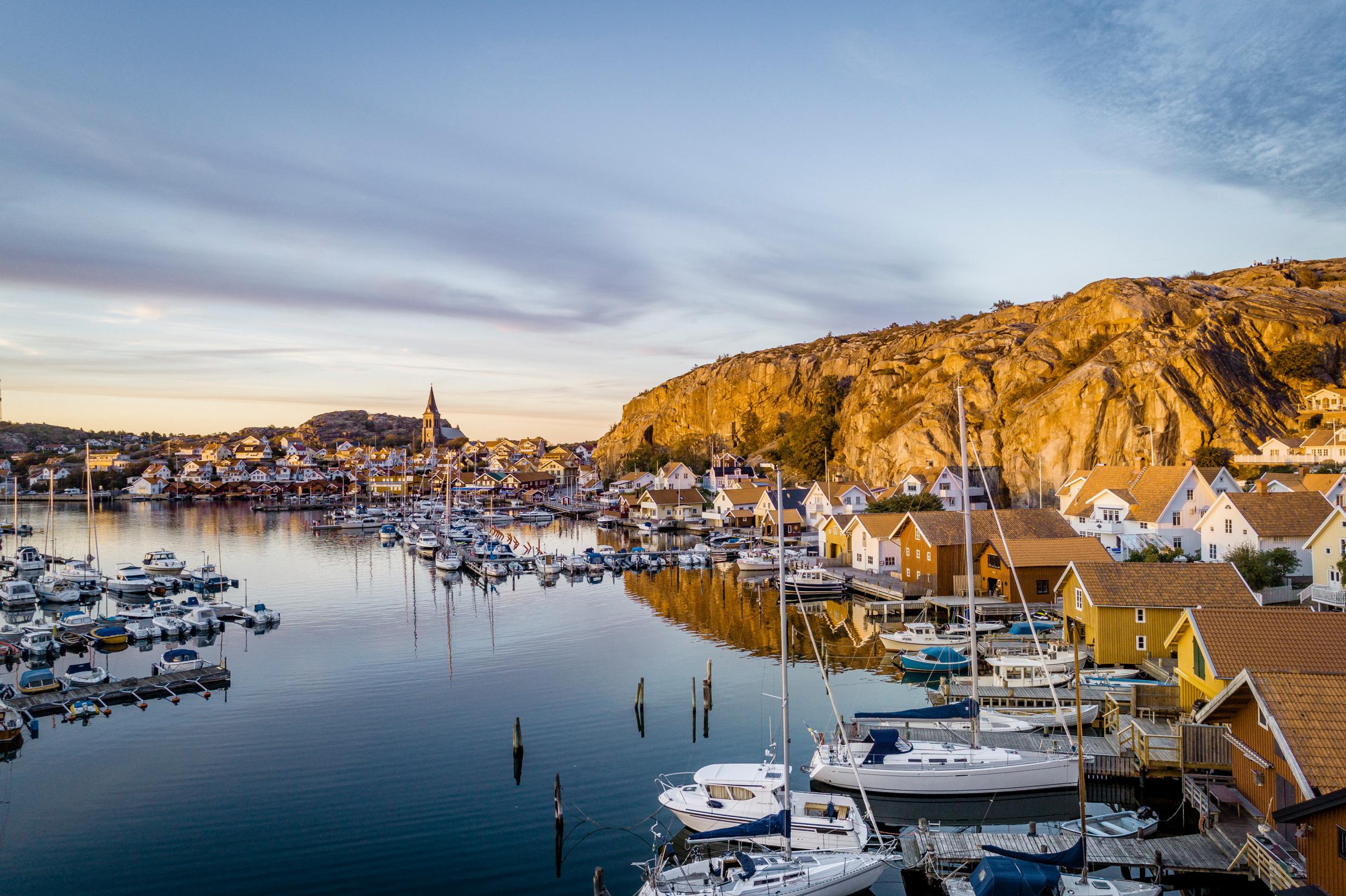 A harbour area with boats, cliffs and buildings.