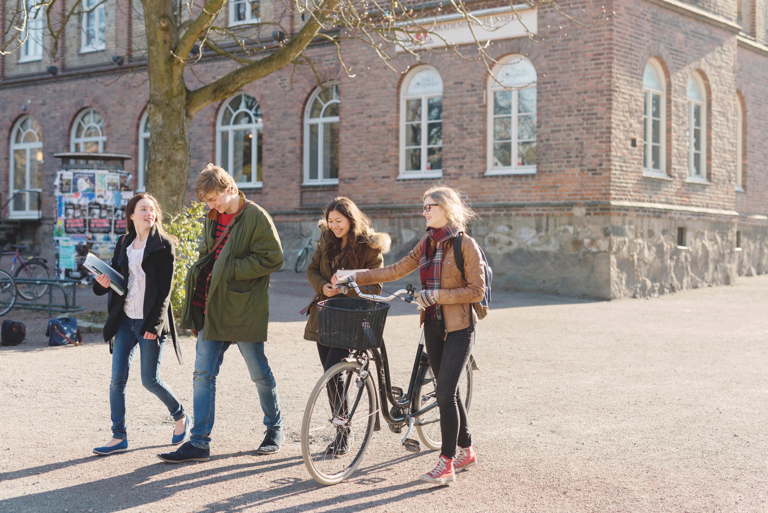 Students walking in front of an old brick buildning.