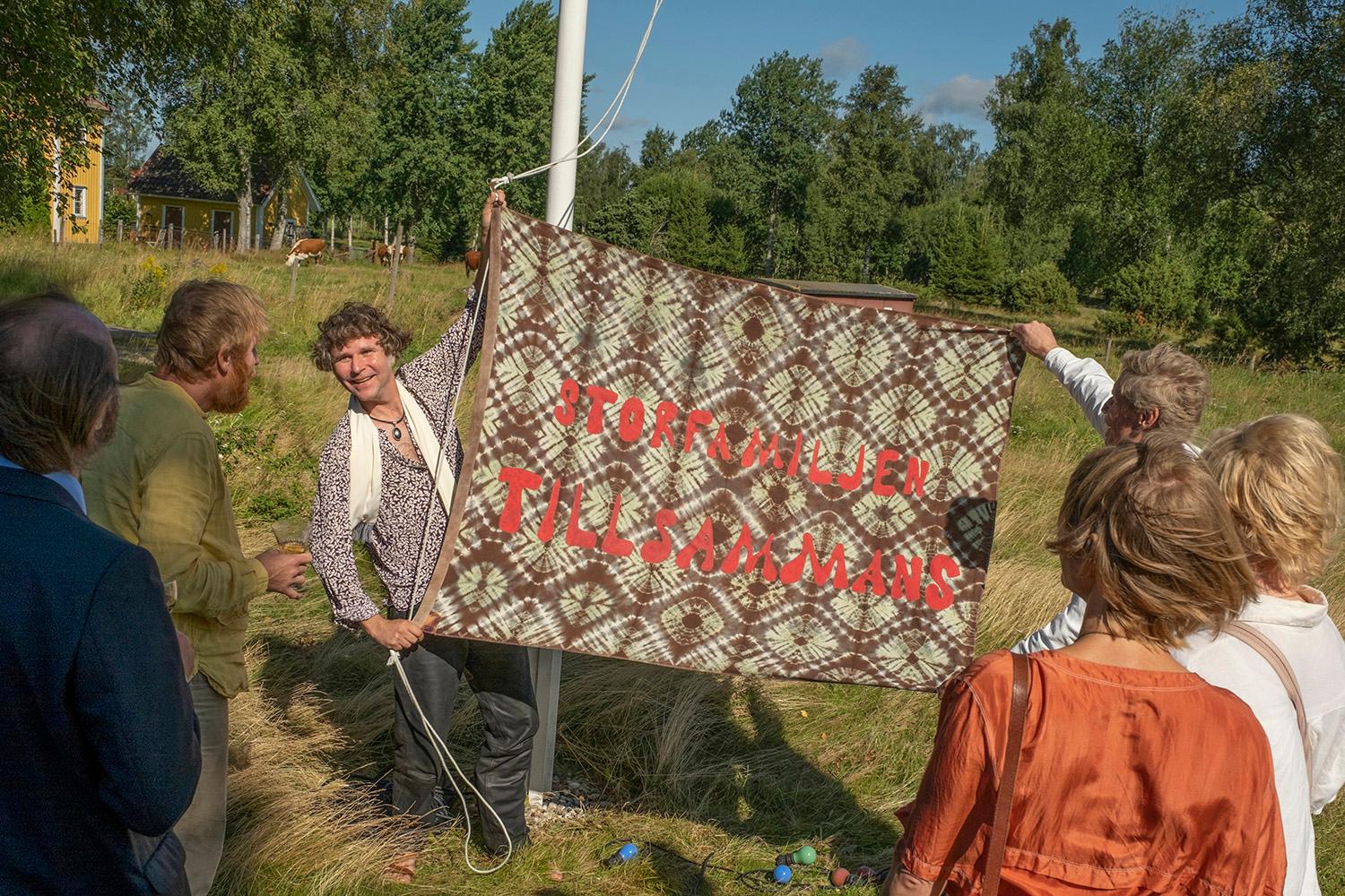 Klasse holding up a banner with the text translated to &quot;The big family Together&quot;